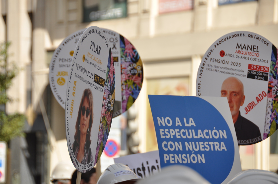 Asociaciones mutualistas - IP - EconomiaeInversion.com Round protest posters with images of people and political messages, carried on sticks during a demonstration about pensions and pensions reform in a city street.