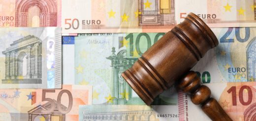 Wooden gavel rests on a collage of euro banknotes, symbolizing money and justice in legal matters.